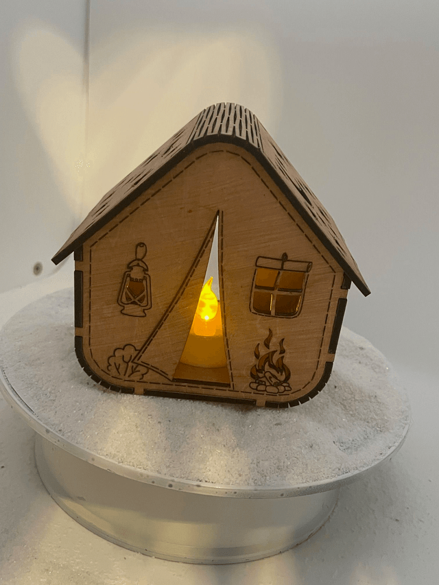 Photophore en bois en forme de tente de camping.